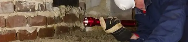 Pest control technician inspecting a crawl space for ant activity and entry points in Marietta, GA