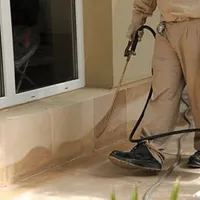 General pest control technician spraying exterior perimeter around a home in Marietta, GA