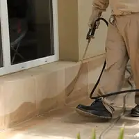 General pest control technician spraying exterior perimeter around a home in Marietta, GA